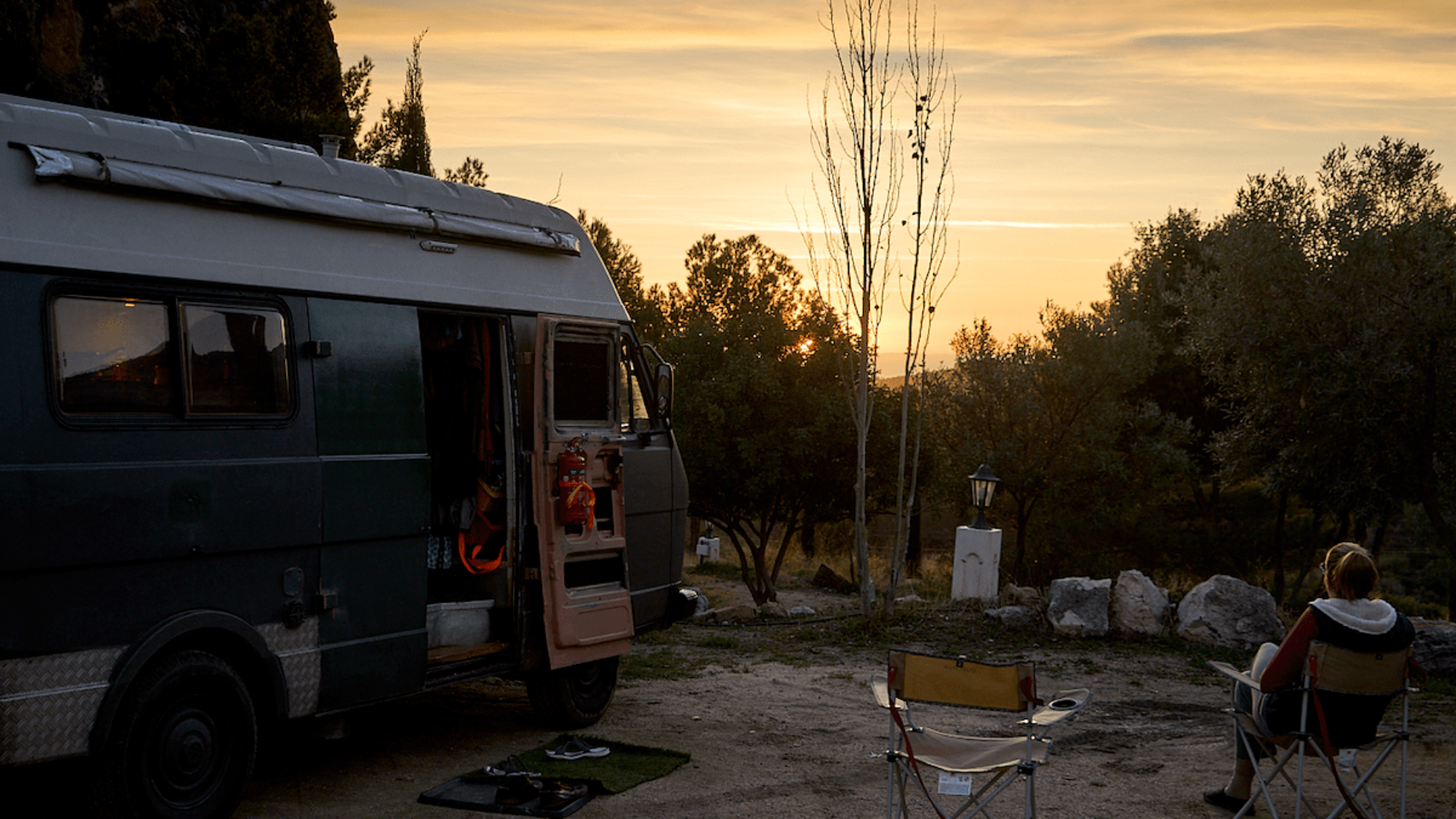 Volkswagen camper staat geparkeerd op een Spaanse camper met zonondersgang