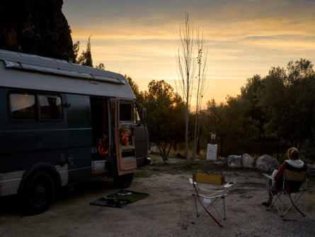 Volkswagen camper staat geparkeerd op een Spaanse camper met zonondersgang